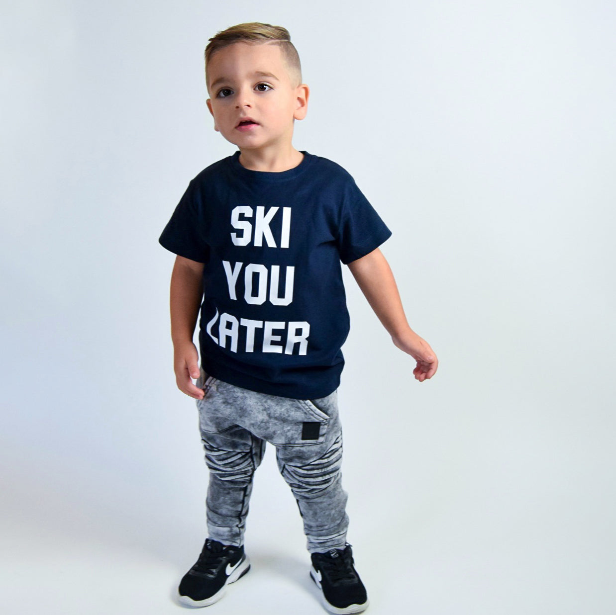 Boy wearing navy shirt with 'Ski je later' print by KMLeon.