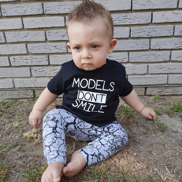 'Models don't smile' baby shortsleeve shirt