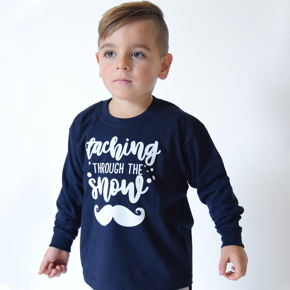 Young boy wearing navy shirt with long sleeves with 'Staching through the snow' print by KMLeon.