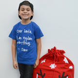 Smiling boy with black cap and blue shirt with 'Santa, I can explain everything' shirt by KMLeon.