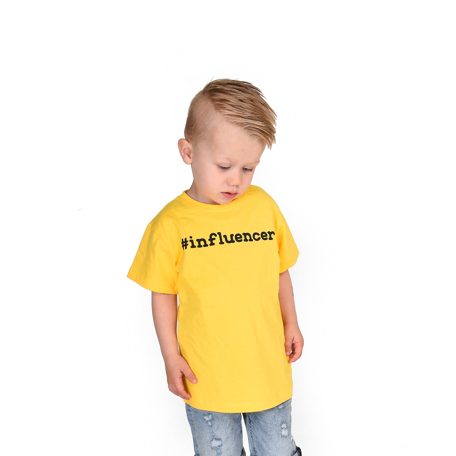 Blonde boy looking at his feet with yellow shirt, with '#influencer' print, by KMLeon.