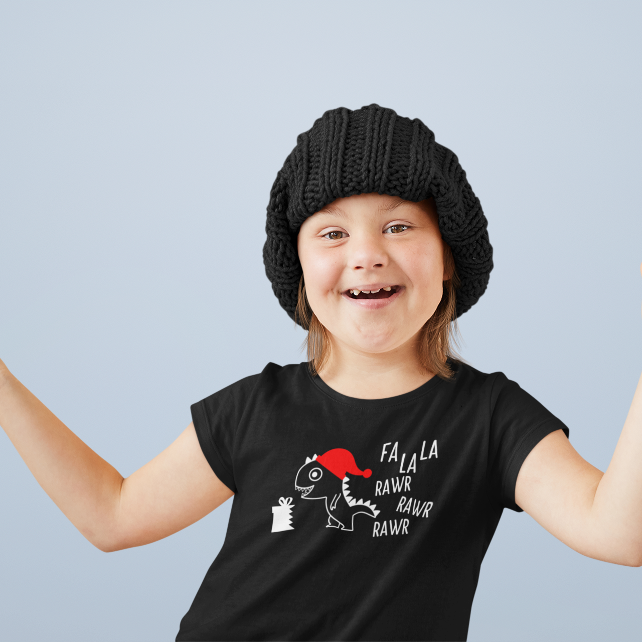 Smiling girl with down syndrome wearing black beanie and black shirt with dino 'Fla La La Rawr Rawr Rawr' print by KMLeon.