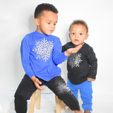 Black brothers wearing shirts with long sleeves with glitter snow star print by KMLeon, playing with snow.