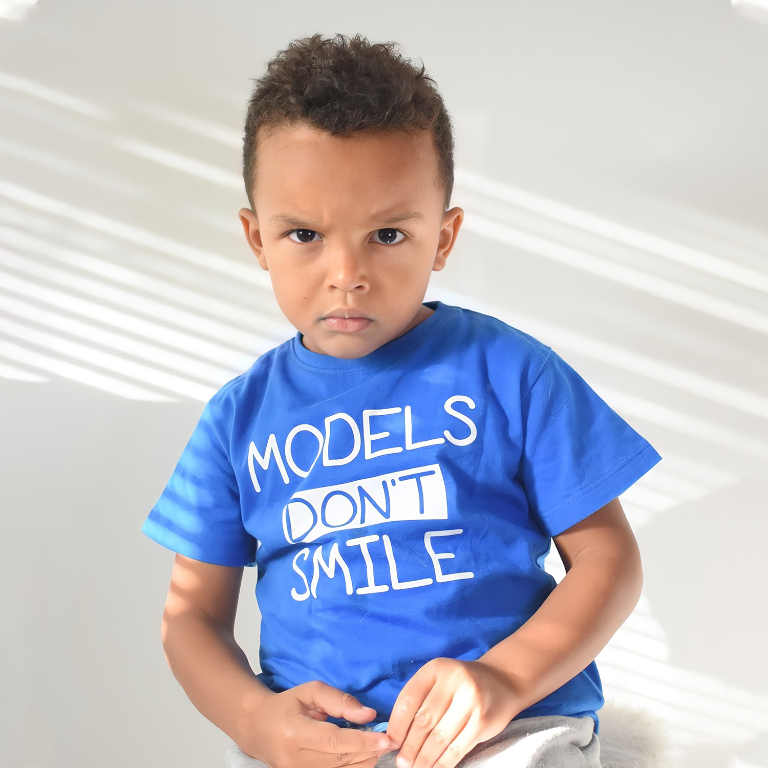 'Models don't smile' kids shortsleeve shirt