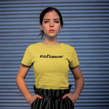 Serious women with yellow shirt with '#influencer' shirt by KMLeon against blue background.