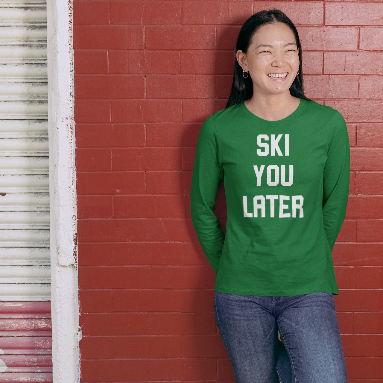 Smiling asian woman with green shirt, with longs sleeves, with 'Ski you later' print by KMLeon.